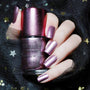 A manicured hand holding Pink Metallic Stamping Polish Ho Ho Ho (B263) by Maniology.