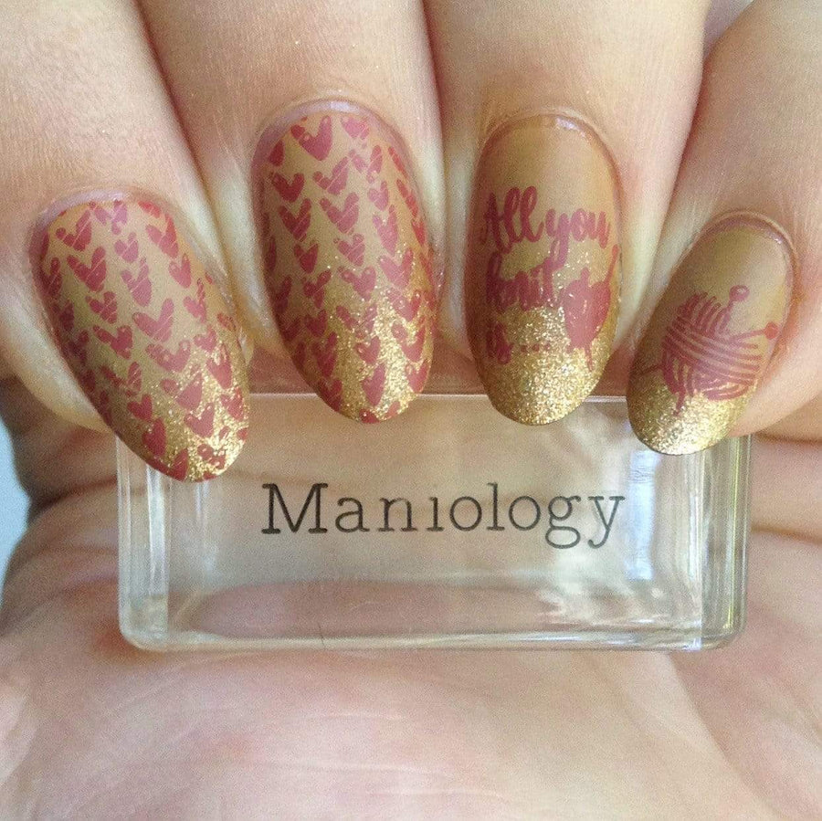 A manicured hand with Knotty by Nature stamping plate designs holding a stamper by Maniology (m177).