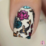 A manicured hand with koi fish and flowers design by Maniology.