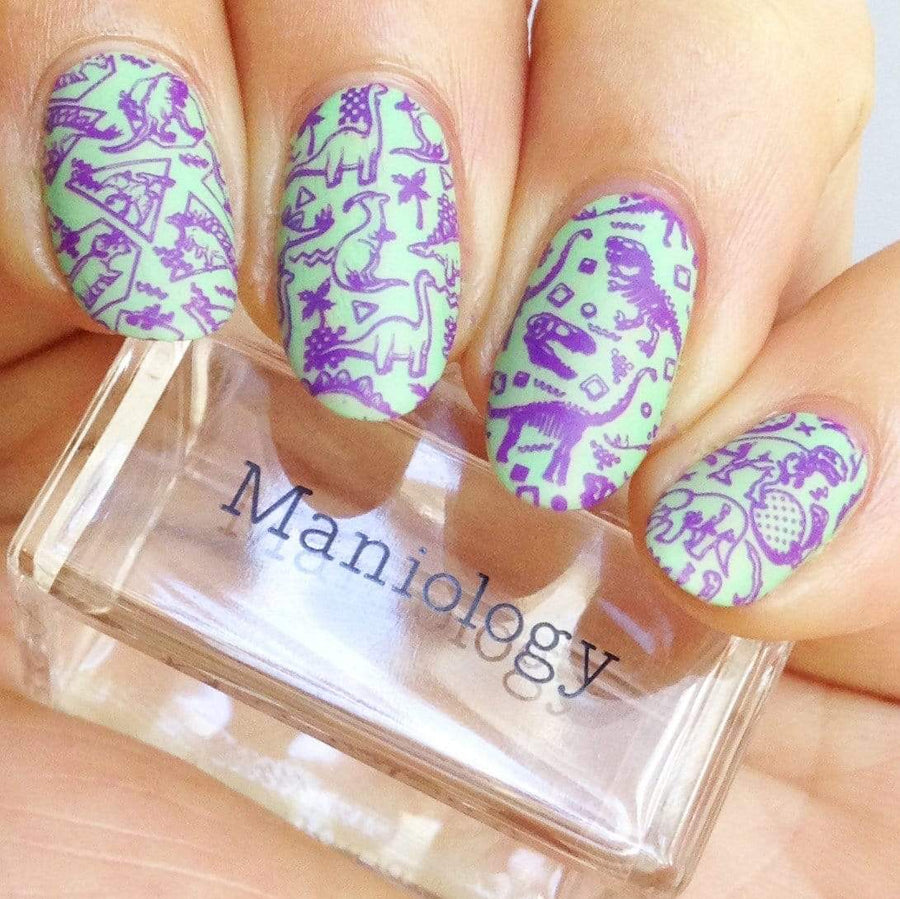 A manicured hand made with Purple Stamping Polish Littlefoot (B281) holding a stamper by Maniology.