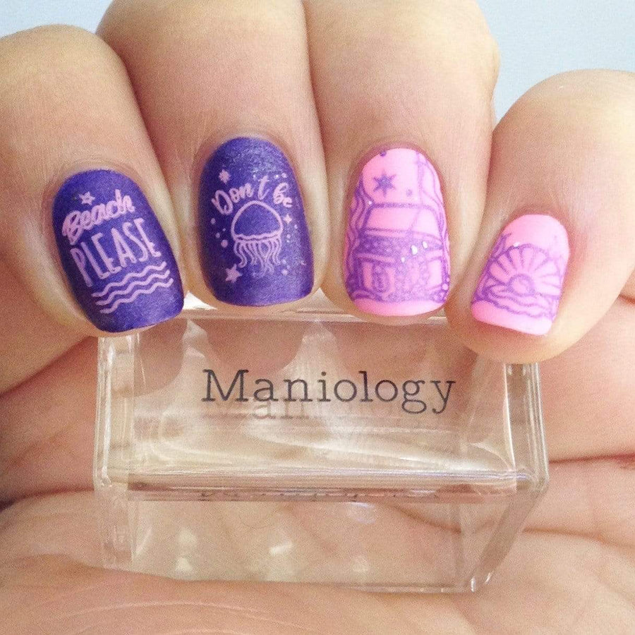 A manicured hand holding a stamper by Maniology.