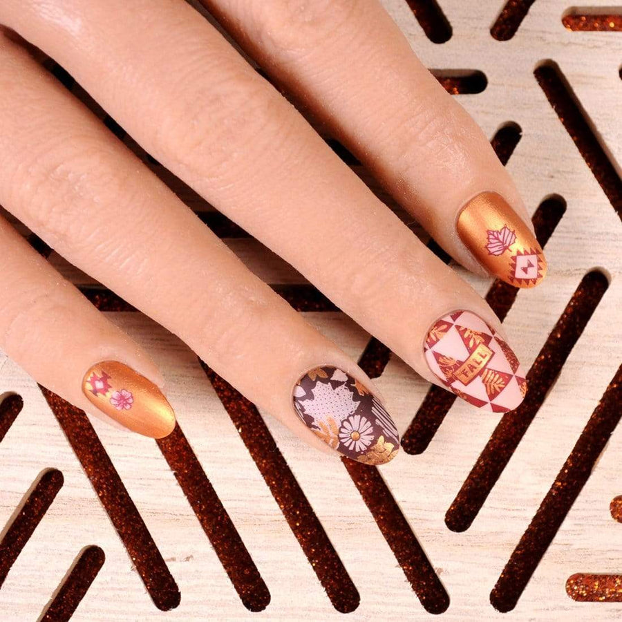 A manicured hand with Copper Orange Stamping Polish.