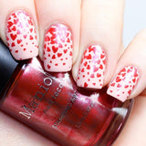 A manicured hand holding Galentine (B329) Metallic Red Stamping Polish by Maniology.