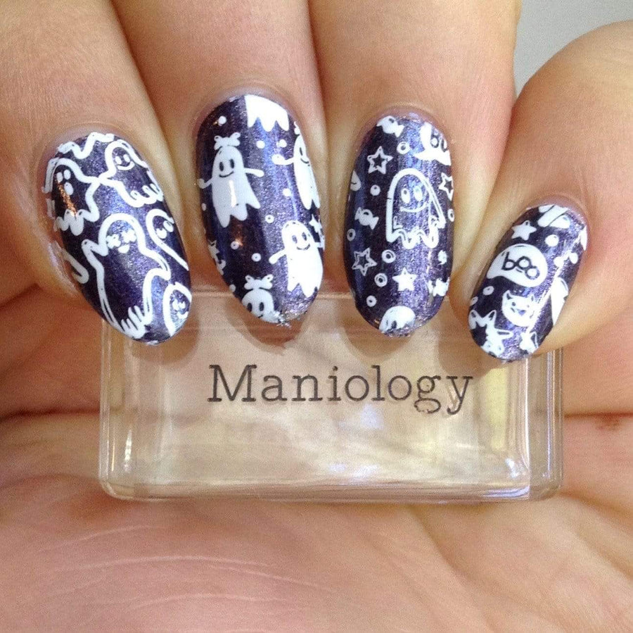 A manicured hand made with purple shimmer stamping polish holding a stamper by Maniology.