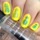 A manicured hand with Pineapple Whip: Party Like a Pineapple designs holding a top coat by Maniology (m051).