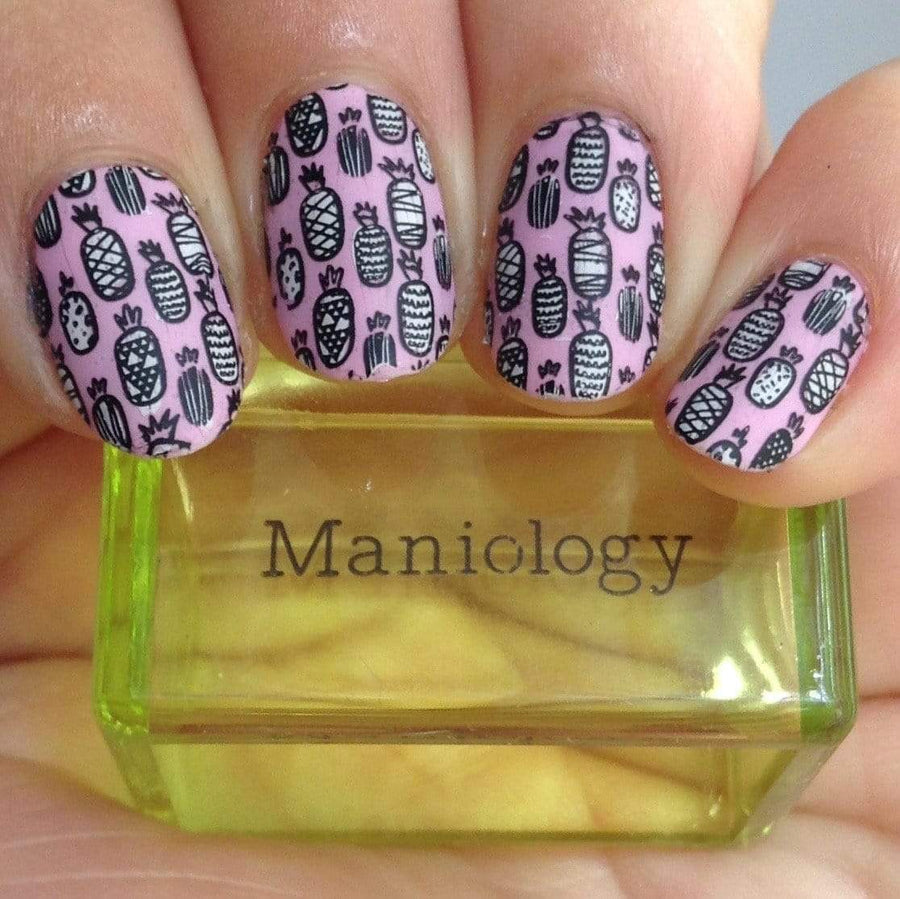 A manicured hand with Pineapple Whip: Party Like a Pineapple designs holding a stamper by Maniology (m051).