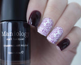 A manicured hand holding sheer purple tinted stamping polish Violet Spectrum (B274) by Maniology.