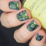 A manicured hand made with Scarab Wings Golden Green Duochrome Nail Art Powder holding a stamping polish by Maniology.