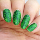 A manicured hand in green with clovers design by Maniology (m048).