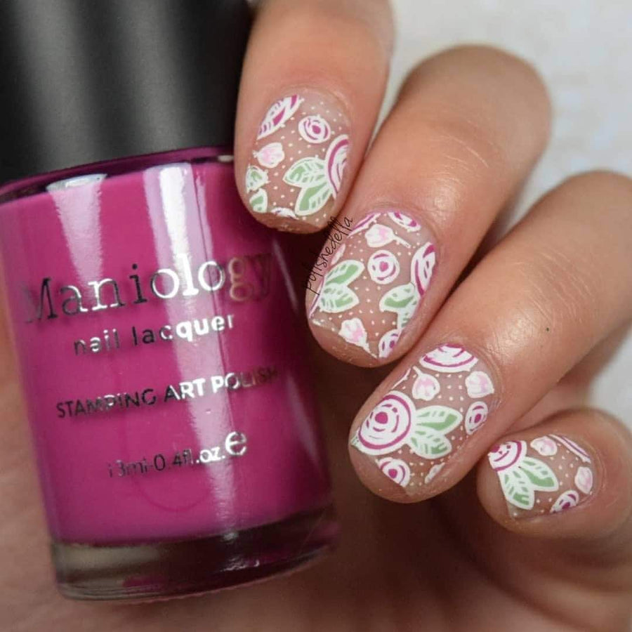 A manicured hand with Bunny Hop design holding a polish by Maniology.