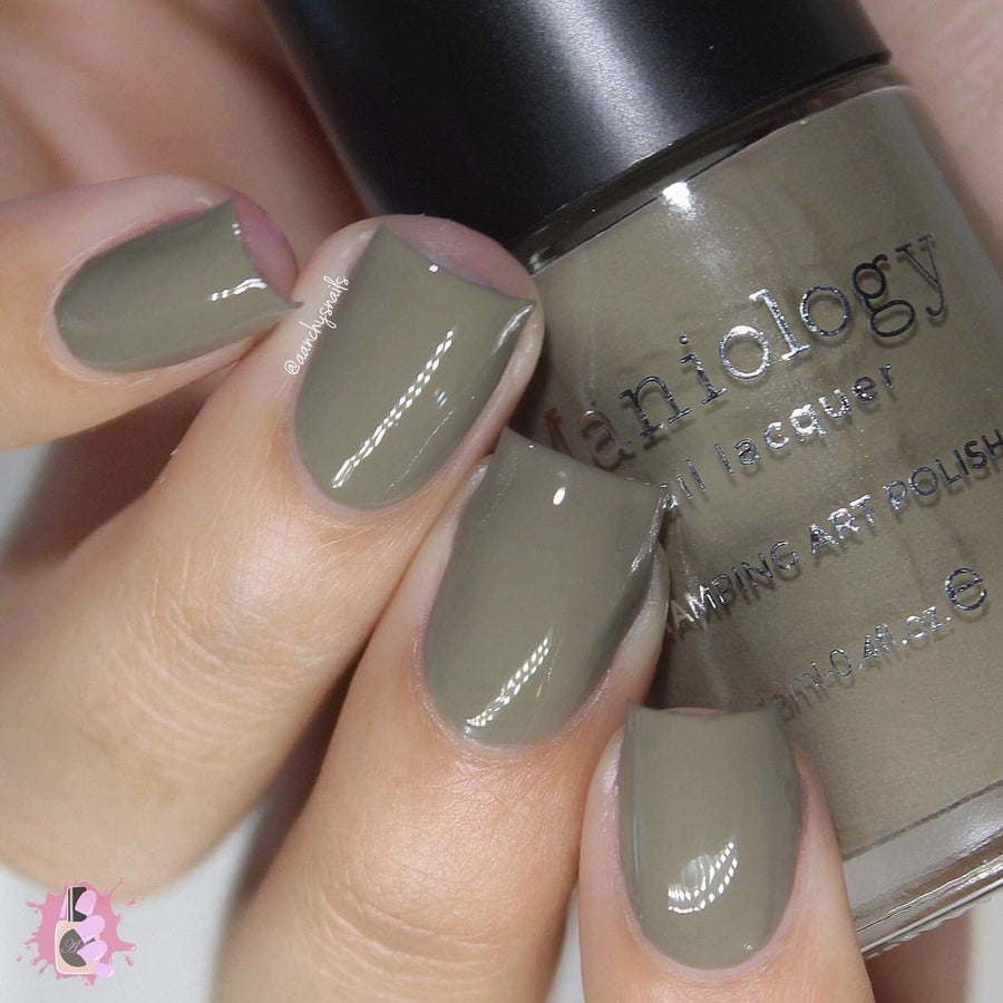 A manicured hand holding Taupe Stamping Polish from Stocking Stuffer collection Down the Chimney (B311).