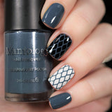 A manicured hand holding Navy Blue Stamping Polish from Stocking Stuffer collection Winter's Kiss (B314).