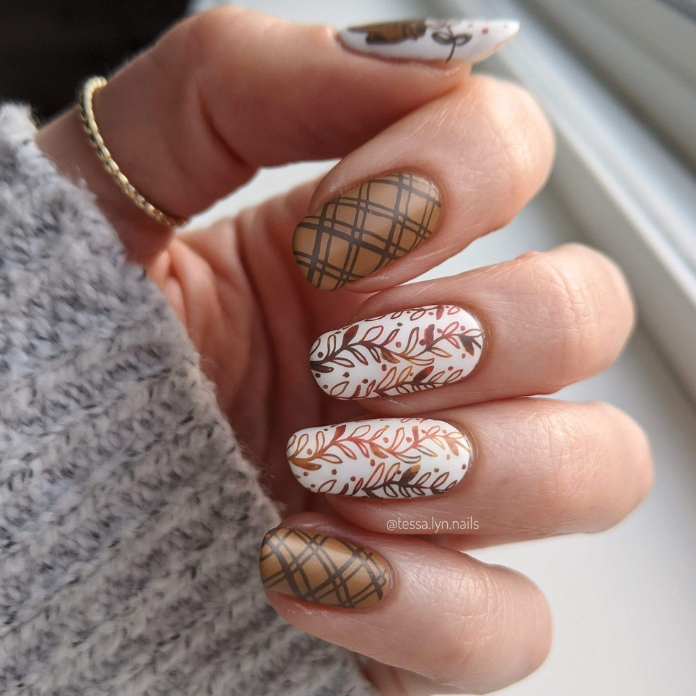 A fall inspired manicure featuring warm colors and leaves.