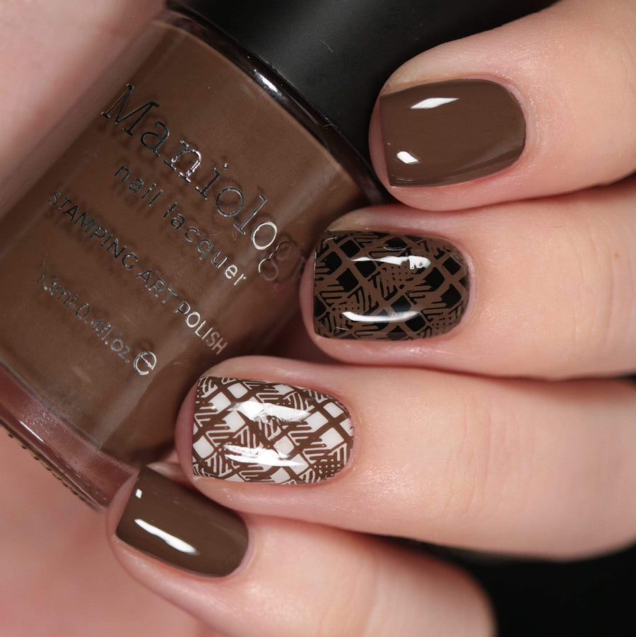 A manicured hand made with warm chocolate brown from Sugar + Spice collection holding a polish by Maniology (B351).