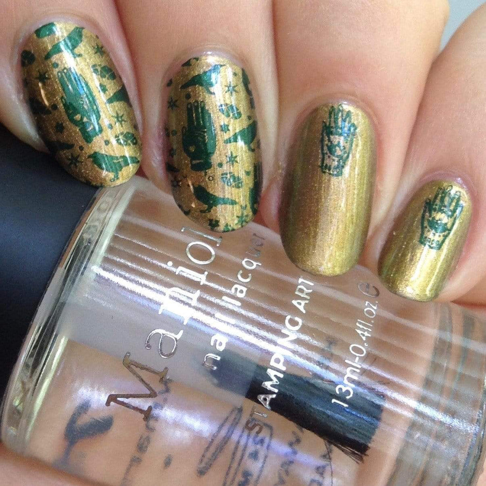 A manicured hand with The Spirit Speaks designs holding a polish by Maniology (m071).