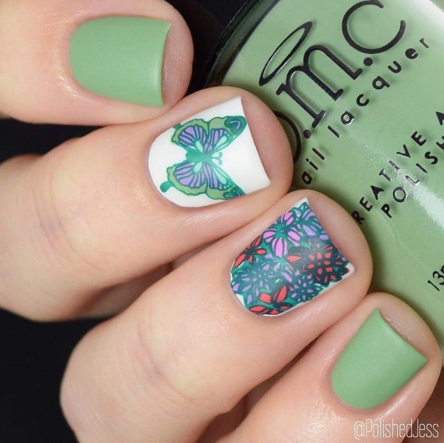 A manicured hand holding a Dusty Green Stamping Polish by Maniology.