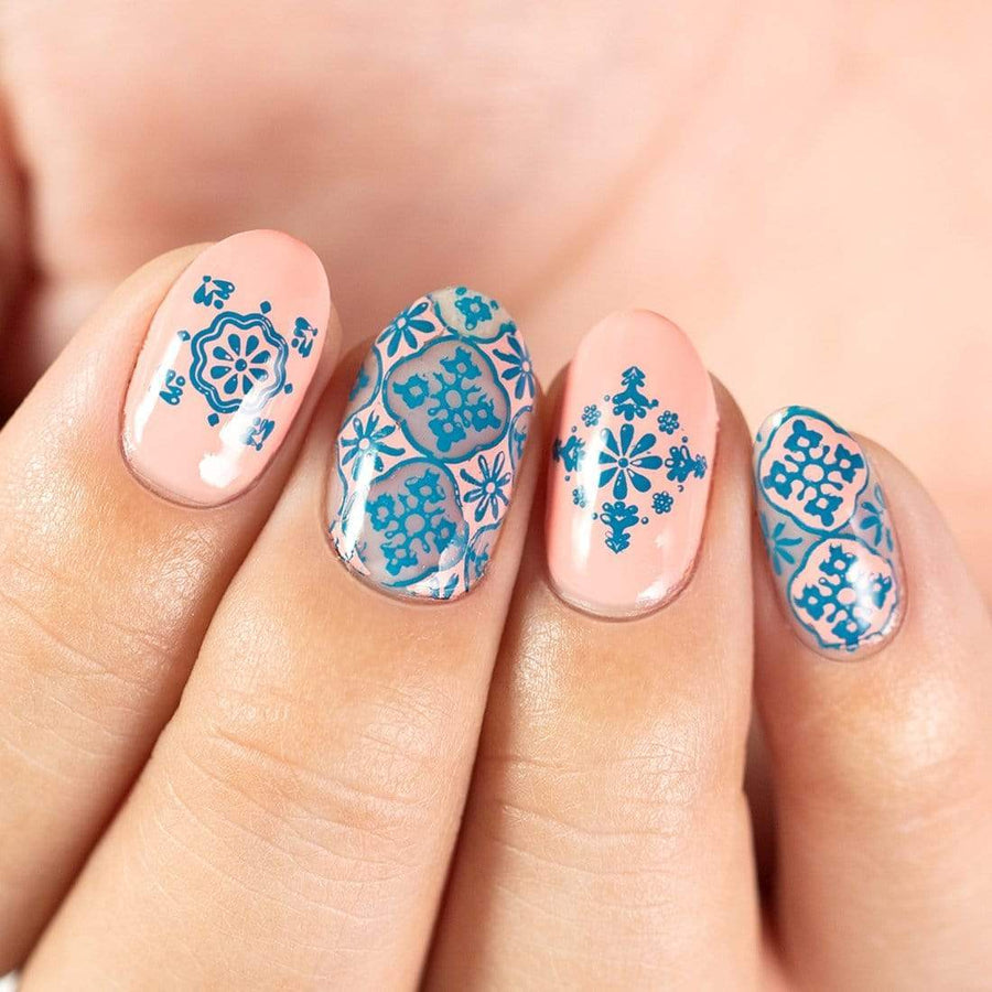 A manicured hand with stamping plate m015 design.