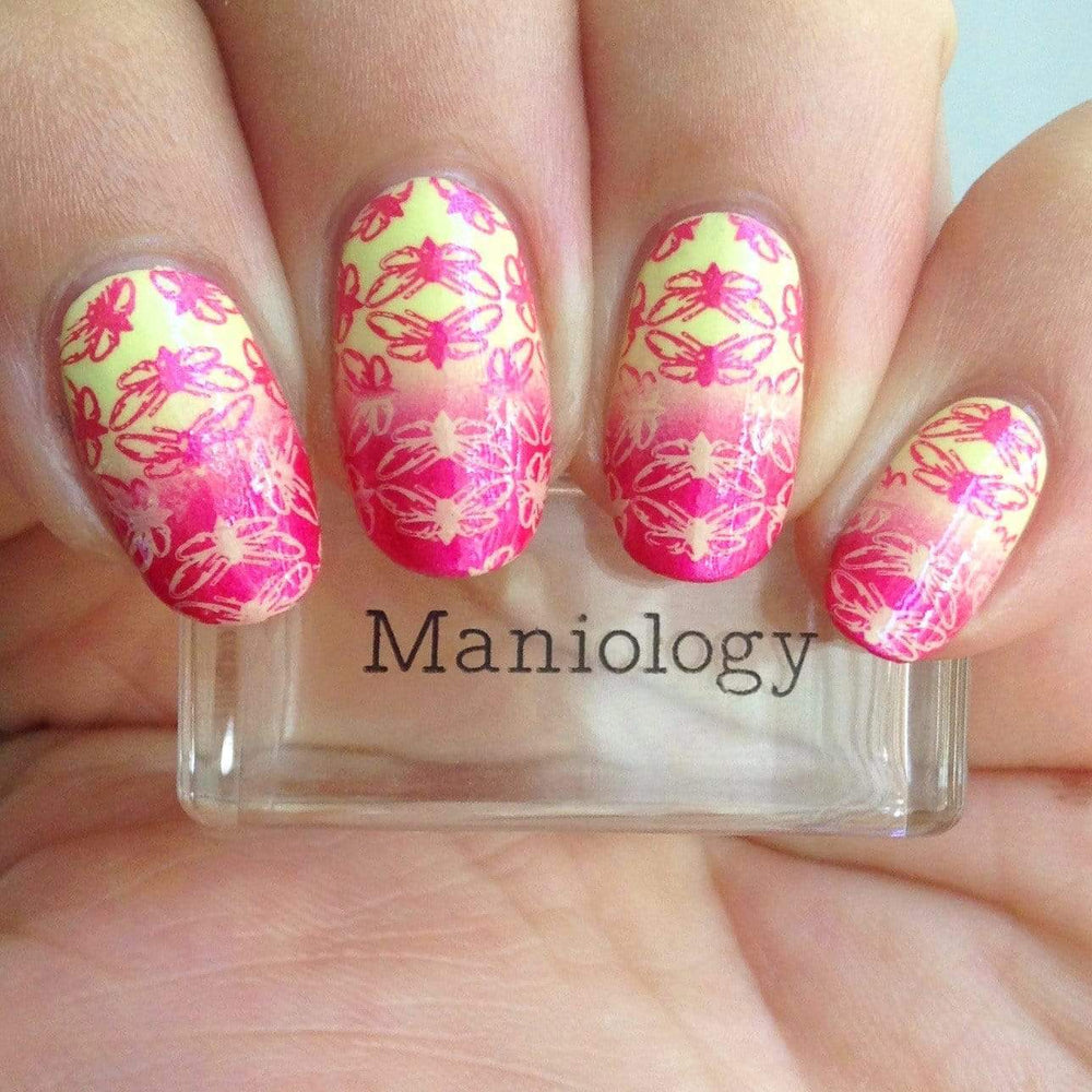 A manicured hand made with Hot Pink Duochrome Stamping Polish holding a stamper by Maniology.