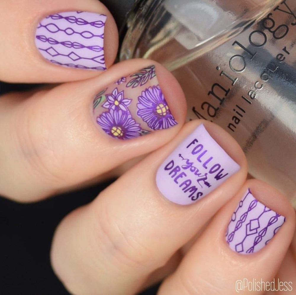  A manicured hand in purple with flowers and statement for women design holding a polish by Maniology (m047).